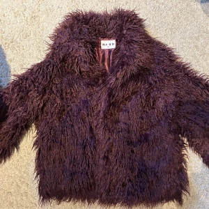 Jacka fuskpäls  - Supersnygg vinröd jacka i fuskpäls från NA-KD, storlek 38. 