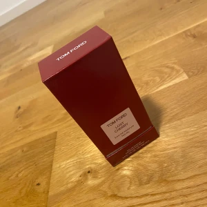 Tom Ford Lost Cherry Eau de Parfum 100 Ml - Tom Ford Lost Cherry Eau de Parfum i en elegant röd flaska med matchande kartong. Doften är känd för sina söta och fruktiga noter, perfekt för den som vill sticka ut. Flaskan har en stilren design med en fyrkantig form och ett genomskinligt lock. Pris kan diskuteras, perfekt för julklapp 🎄😊