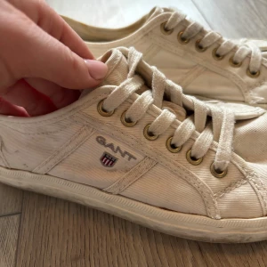 Vita sneakers från Gant - Säljer ett par vita sneakers från Gant med snörning och klassisk design. Skorna har en diskret logga på sidan och är perfekta för en avslappnad stil.