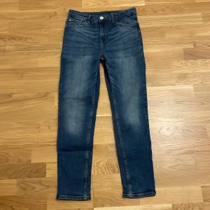 Blå jeansbyxor - Snygga blå jeansbyxor med en klassisk femficksdesign. De har en normal passform och är perfekta för en avslappnad stil. Byxorna har en knapp och dragkedja framtill.