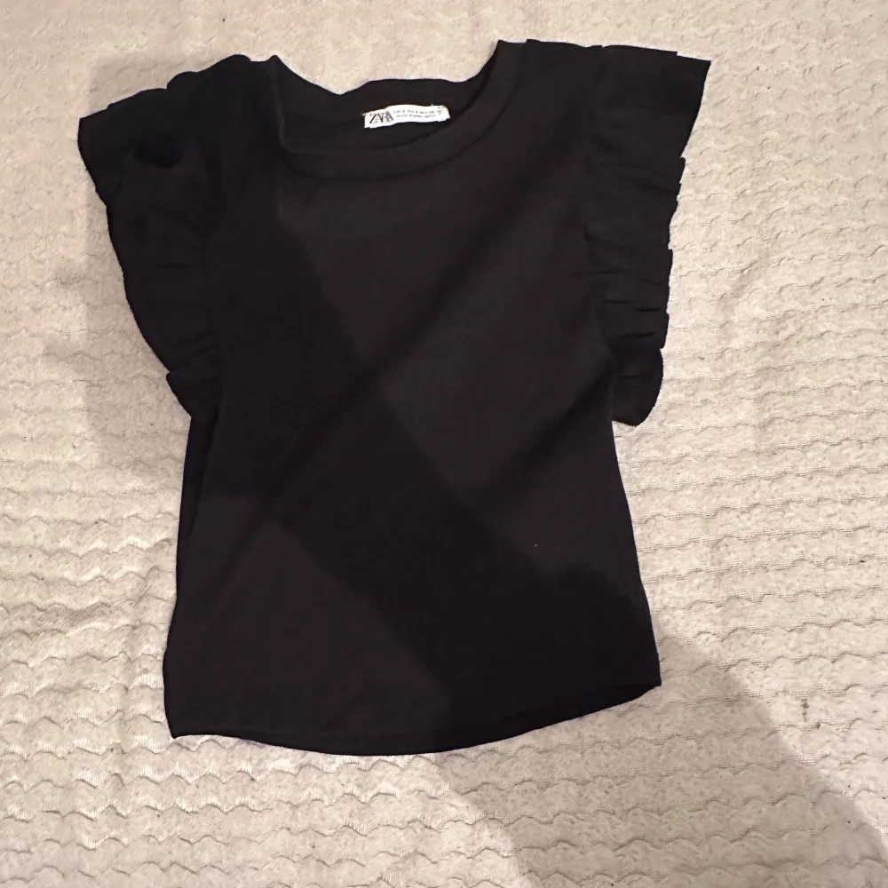 Snygg svart topp från Zara med volangdetaljer på ärmarna🤍 Den är i nytt skick och jag har aldrig använt den (endast testat på). tröjan är stretchig. Storleken S. ❤️. Yläosat.