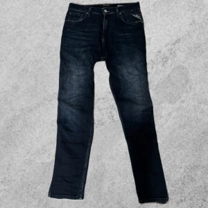 Mörkblå jeans från Replay - Snygga mörkblå jeans från Replay med klassisk femficksdesign och knappgylf. Perfekta för en stilren look. Märkesdetalj på bakfickan ger en extra touch. Priset kan diskuteras!