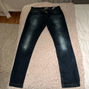 Mörkblå jeans från Dolce & Gabbana - Snygga mörkblå jeans från Dolce & Gabbana med en regular passform. Jeansen är tillverkade i en bomullsblandning med lite ull för extra komfort. Passar storlek 33-34 Perfekta för en stilren look. Obs! Slitning på knät är design! Pris kan diskuteras 