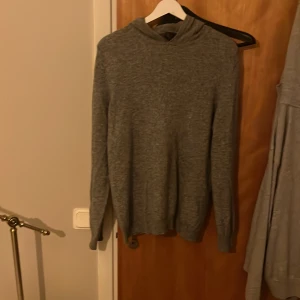 Grå hoodie från Oscar Jacobson - Säljer en stilren grå hoodie från Oscar Jacobson. Tröjan har en mjuk och bekväm passform med långa ärmar och en klassisk huva. 