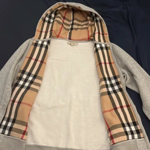 Burberry hoodie - Asfet burberry hoodie i den klassiska gråa färgen. Size L sitter mer som en M. Modellen på bilden är 190 men tröjan passar alla mellan 175-190. Vid fler frågor är det bara att skicka iväg ett meddelande💯
