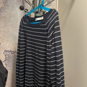 Randig långärmad tröja från Zara - Säljer en stilren mörkblå och vit randig långärmad tröja från Zara. Perfekt för en avslappnad look. Tröjan har en rund halsringning och är gjord i ett mjukt material.
