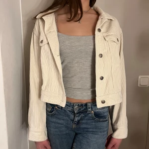 Beige manchesterjacka - Snygg beige manchesterjacka med knappar framtill. Jackan är croppad och har en klassisk krage. Perfekt för höst och vår🫶