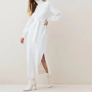 Karen Millen stickad klänning - Vit stickad klänning med slits från Karen millen.  Aldrig anvand. Ny utan prislapp. Storlek XS. Färgen Ivory