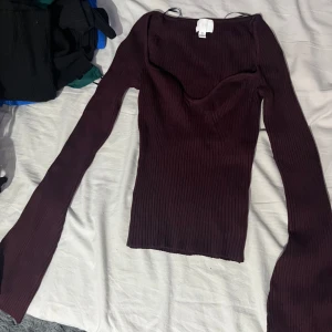 Vinröd ribbad topp från Hm  - Snygg vinröd ribbad topp med lång ärm och v-ringad hals. Perfekt för höst och vinter, denna topp är både stilren och bekväm.Aldrig använt den endast testat den en gång .