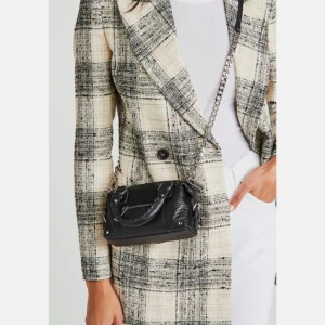 NYTT Svart handväska från Núnoo mini Bobby  - Snygg svart handväska från Núnoo i skinn med silverfärgade detaljer. Väskan har en praktisk dragkedja framtill och en avtagbar axelrem i kedja. Perfekt för att ge din outfit en cool touch. Väskan är oanvänd med prislapp kvar. Kommer med tags, tillhörande nyckel till låset. 100% läder