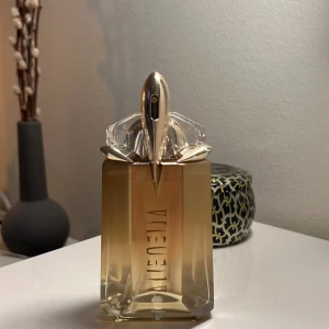Alien Eau de Parfum från Mugler - Säljer denna parfym med en söt och god doft. Har endast använt fåtal gånger. Flaskan är 60 ml skulle säga att det är runt 55 till 50 ml kvar, man kan även se på bilden ovan hur mycket det är kvar. Parfymen är köpt för 1430kr. 