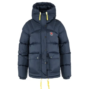 Mörkblå dunjacka från Fjällräven - Jackan är använd fåtal gånger. Snygg och varm mörkblå dunjacka från Fjällräven med huva och gula detaljer. Jackan har knappar och dragkedja framtill samt praktiska fickor. Perfekt för kalla dagar. 