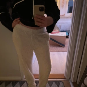 Vita mjukisbyxor från NLY Trend - Mysiga vita mjukisbyxor från NLY Trend i fluffigt material. Perfekta för en avslappnad dag hemma. Byxorna har en bekväm passform och är idealiska för kyligare dagar.