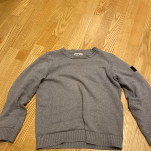 Grå tröja från Stone Island - Säljer nu min stone island hoodie. Den är i stickat material och går till allt. Säljes pga för liten. Ny pris 3500. Villig att sänka pris vid snabb affär 