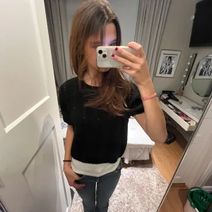 Svart kortärmad topp - Säljer en stilren svart topp med korta ärmar. Perfekt för en avslappnad look. Toppen har en enkel design och är lätt att matcha med olika outfits.