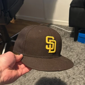 Brun fitted keps  - Keps köpt i nyc storlek 7  1/2 eller 59,6 cm. Använd men i bra skick