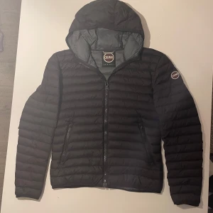 Svart dunjacka från Colmar - Snygg svart dunjacka från Colmar med huva och dragkedja. Jackan är i mycket bra skick.😁 Perfekt för kyligare dagar nu vid höst och vinter. Priset är ej hugget i sten. 🪨 Skriv vid minsta lilla fundering.😁😁