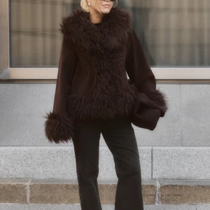 Moa mattsson x NA-KD Jacka  - Snygg brun pälsjacka med fluffiga detaljer runt krage, ärmslut och nederkant. Perfekt för att hålla sig varm och stilren under kyliga dagar. Jackan har en normal passform och är långärmad.