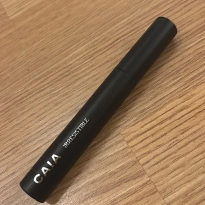 Svart mascara från CAIA - Snygg och elegant svart mascara från CAIA med texten 'IRRESISTIBLE' på hylsan. Perfekt för att ge dina fransar volym och definition. Helt oanvänd