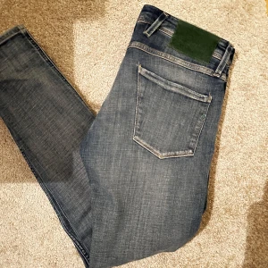 Replay - Tja säljer nu ett par Replay Anbass. Skicket är 9/10 inprincip helt oanvända. Storlek 30/32 och kostar endast 499kr. Nypris 1349kr. Det har en skön grön detalj som inte många har på batchen och knappen framtill, skön tvätt också. Skriv vid eventuella funderingar eller frågor🔥