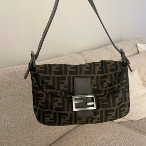 Fendi baguette väska  - Säljer min fina fendi baguette köpt på the vintage bar! Nypris 9000kr. Certifikat från thevintagebar medföljer samt kvitto på mejl! 