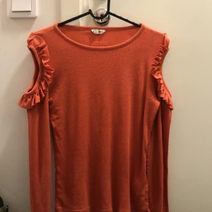 Orange topp från cubus - Orange långarmad topp  med hål i axlarna 