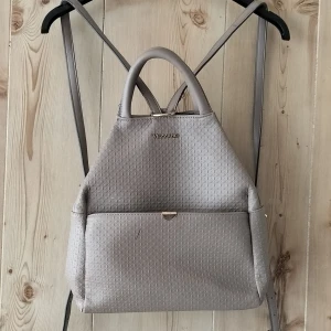 Brun/beige dam väska  - Säljer en använd damväska. Stilren och i gott skick, med några skavanker. Insidan är smutsig och jag är osäker på tvätt. Utsidan har bläck märken. Alla dragkedjor fungerar. Endast upphämtning. Betalning via swish och kontant. Sms: 0735865586.