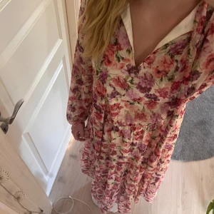 Blommig långklänning - Långklänning med knytbar krage, lång passform, aldrig använd med prislapp kvar