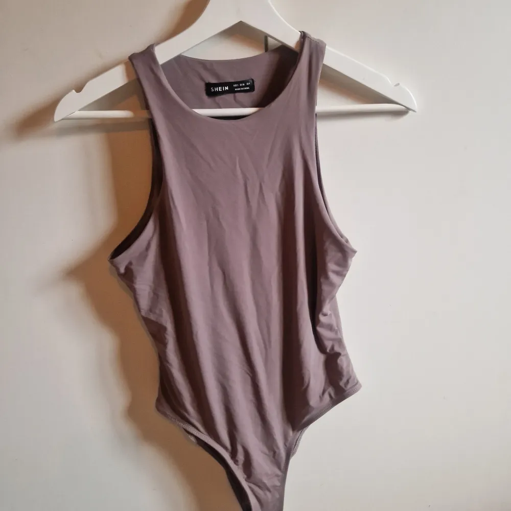 Säljer en stilren lila bodysuit från Shein. Den är ärmlös och har en enkel design som passar perfekt till både vardag och fest. matrialet är lite 