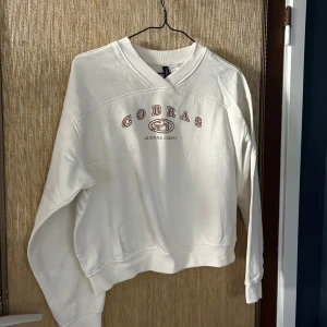 Vit sweatshirt från Arizona Cobras - Säljer en vit sweatshirt med Arizona Cobras-tryck på bröstet. Tröjan är i bra skick och har en normal passform. Perfekt för höst och vinter! 🐍