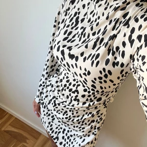 Mönstrad kort klänning med ärmar - Säljer denna otroligt fina klänning som är perfekt för sensommaren! 