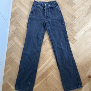 Grå jeans från Never Denim - Ett par mörkgråa jeans från never denim. bra skick förutom lite slit längst ner. Är u modellen regular wide. 
