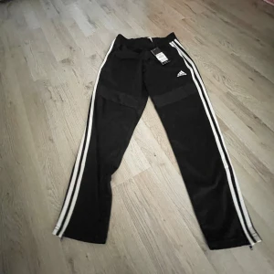 Svarta träningsbyxor från Adidas - Säljer ett par svarta träningsbyxor från Adidas i storlek 152. säljer då dem är för små vid funderingar och frågor så är det bara att höra av sig svarar på allt.nyskick och har fortfarande etiketten kvar.