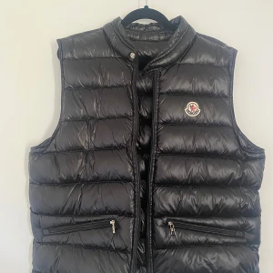 Moncler Gui Väst - Säljer de här västen då den är för liten. Västen är i väldigt bra skick knappt använd. Den är i stl 2 motsvarande s/m, Skriv vid frågor, mer bilder eller likande. Priset är ej hugget i sten.