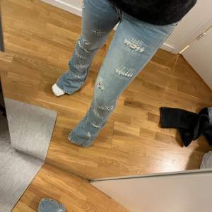 Lågmidjade acoola jeans. Utsvängda i modellen. Jättesnygga små hål som sitter lite överallt. Aldrig använda då de har varit försmå (har försöka göra de större genom att klippa på sidorna, se sista bilden). Det står ingen storlek men skulle gissa xs/s