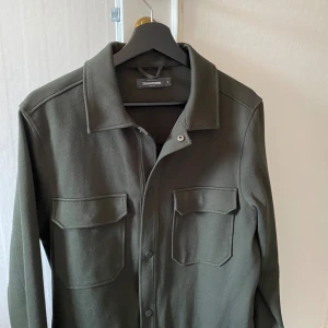 Overshirt - Säljer denna schyssta ”overshirt” från dressman då den aldrig kommer till användning - skick 10/10, jag har bara använt den ett par gånger. Nypris ligger omkring 500kr, mitt pris 300kr, men det är inte hugget i sten👍