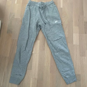 GRÅA NIKE BYXOR - Gråa Nike mjukisbyxor🩶Säljer för att de inte används längre💕 De har en liten fläck där nere vid vaden på ena sidan men inget som syns jättemycket💕De passar både tjejer och killar!