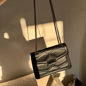 Svart väska  - Fint skick, lite sliten vid knappen