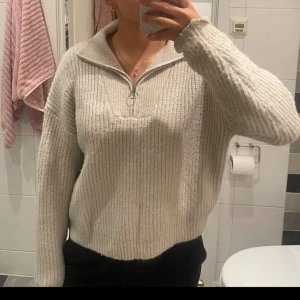Halfzip stickad tröja - En beige stickad tröja med half zip. Storlek M. Lite luddig där av det väldigt väldigt billiga priset