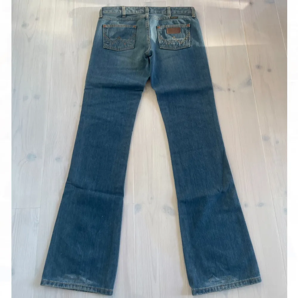 Lågmidjade utvängda wrangler jeans. Helt nya! Prislapparna som syns på 2:a bilden har lossnat men jeansen är helt oanvända! Midjemåttet: 71cm Innerbenslängden: 86cm. Jeans & Byxor.