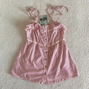 Bershka randig röd sommartopp med volanger - Otroligt gullig randig röd / vit topp från Bershka med volanger och knappar. Ny med prislappar. Storlek L men liten i storleken och skulle rekommendera den för M/S. Säljer en likadan blå i en annan annons.