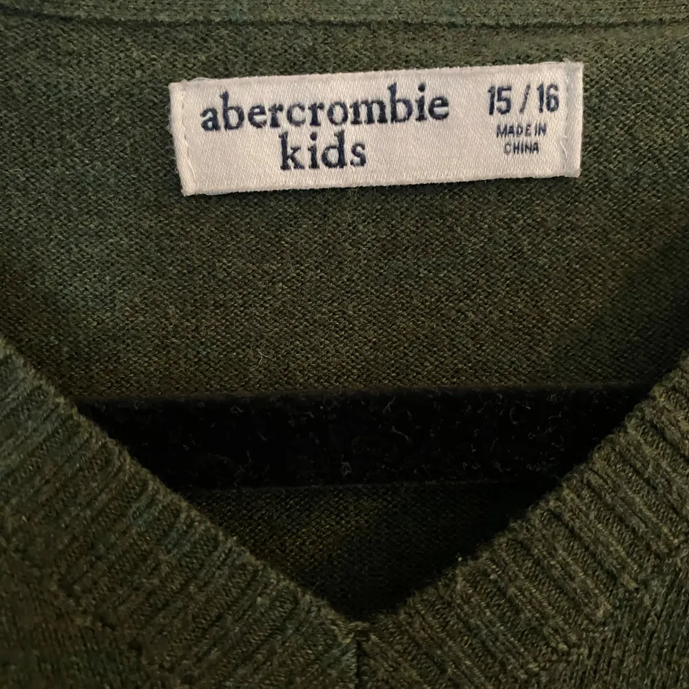 Säljer en snygg grön tröja från Abercrombie  i storlek 15/16/xs/s. Tröjan har en klassisk v-ringning och är långärmad, perfekt för höst och vinter. Den är i bra skick och har en liten vit logga på bröstet. Supermjuk och bekväm! Hör av dig vid minsta fundering👑👊Pris kan diskuteras . Tröjor & Koftor.