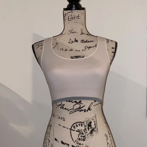 Träningsbehå - • Bra skick, använt plagg • Upplevs som 38 (stor 36),(står XS/S) • Passform normal, ganska stretchigt tyg på övre halvan så håller inte upp jättehårt • Bild 4 visar färg och material bäst (mörkt vit) • Material 98%Nylon, 2%Polyeste • Fråga gärna!