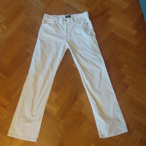 Vita jeans från JOOP! - Säljer ett par snygga vita jeans från JOOP! i storlek 34/34. De är tillverkade av 98% bomull och 2% lycra, vilket gör dem både bekväma och stretchiga. Perfekta för en stilren look!