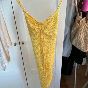 Gul miniklänning!  - Supersöt klänning från Bersksha i storlek XS. Har ingen bild på då den blivit för liten. Axelbanden går i korsningen ryggen! Använd fåtal hänger så väldigt bra skick☺️