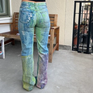 Målade jeans - Ett par sypercoola jeans! har färgat möster på hela tyget. lagom högmidjade. sitter tajt men blir mer lösa nertill. hittar ingen storlek men skulle säga passar xs då de är lite små för mig som annars har s🌟