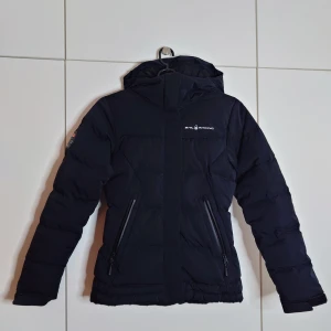 Sail Racing Drift jacka - Sail Racing drift jacket i storlek XS, väldigt varm och skön. Sitter snyggt på och den går att spänna in vid midjan samt ärmslutet för att "låsa" in värmen. Vattentåliga fickor på utsidan. 3st innerfickor var av en av dom har dragkedja. 