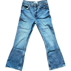 Blå bootcut jeans från Zara - Säljer ett par snygga blå bootcut jeans från Zara. De är sparsamt använda och i fint skick, de har slitningar längst ner på benet (osäker om det är en del av designen eftersom de har likadana slitningar på fickorna) visas på sista bilderna. 