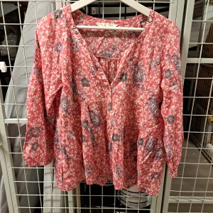 Rosa blommig blus från Odd Molly - Säljer en superfin rosa blus från Odd Molly med ett härligt blommigt mönster. Blusen har trekvartsärmar och en avslappnad passform, perfekt för vår och sommar. Den är gjord i ett mjukt bomullsmaterial som känns skönt mot huden.