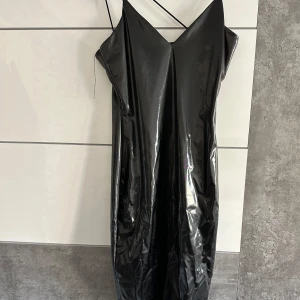 Svart klänning från SHEIN - Säljer en snygg skinnklänning från SHEIN i storlek S. Klänningen är axelbandslös med en elegant v-ringning. Perfekt för festliga tillfällen. Aldrig används pågrund av fel storlek 